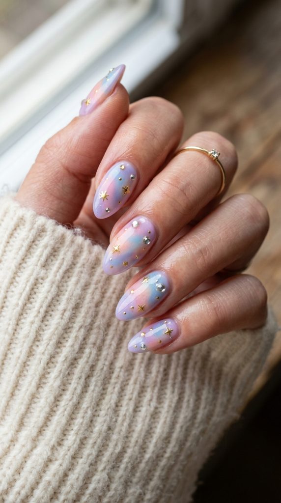 Celestial aura nails topped with tiny gold stars and rhinestones