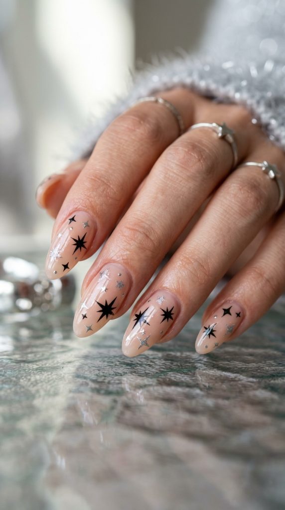 Y2K nails with black and silver stars on nude