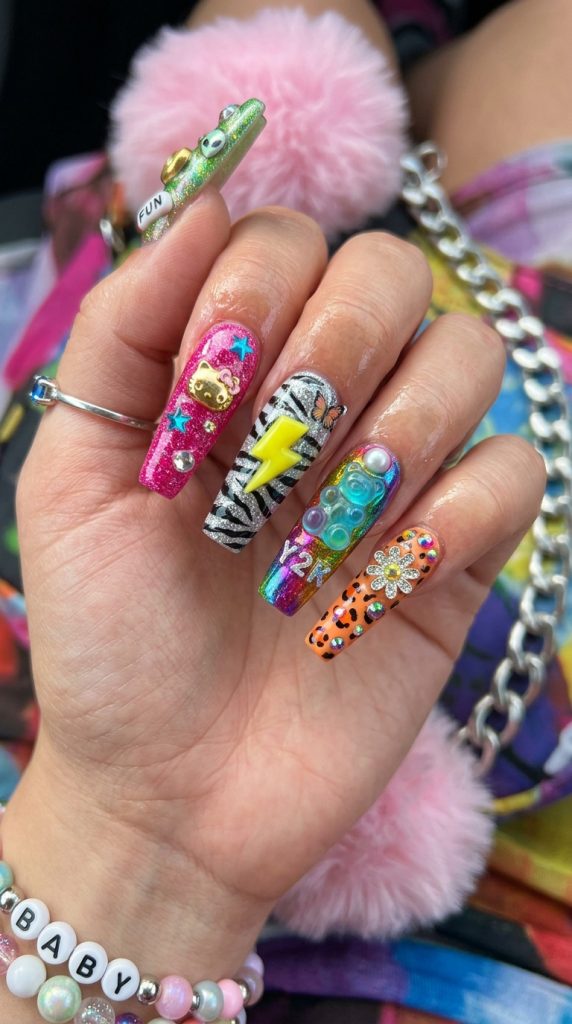 Maximalist Y2K nails mixing chrome, print, and charms