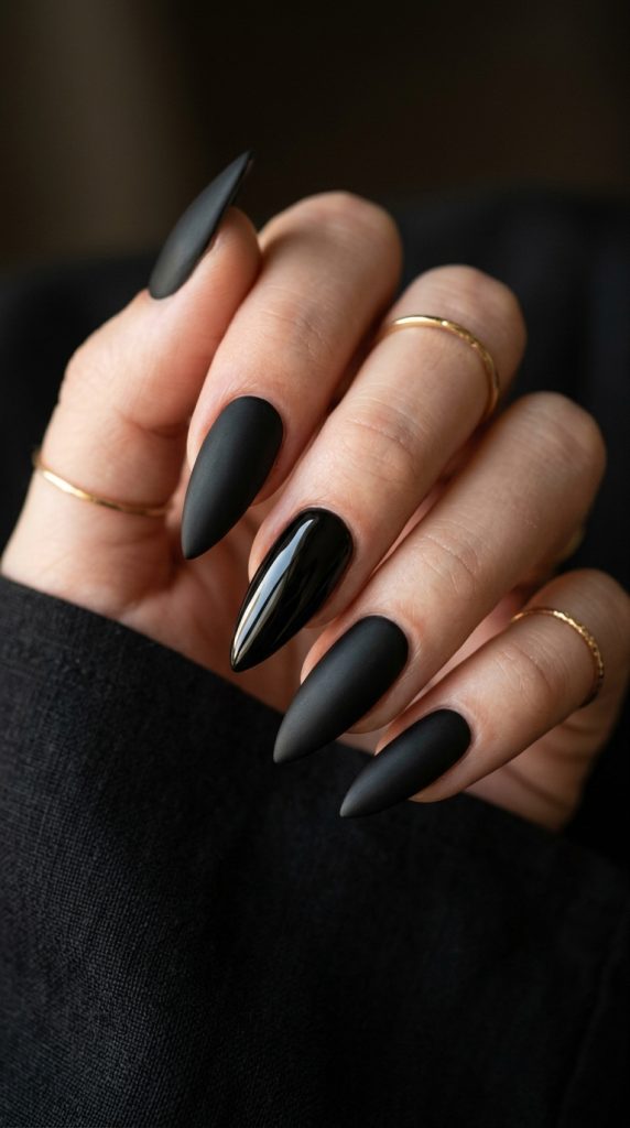Matte black stiletto nails with a glossy accent