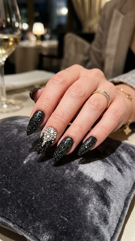 Black stiletto nails with a rhinestone accent