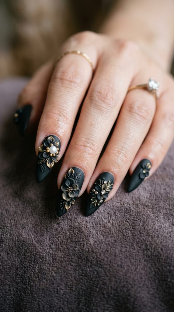 Matte black stiletto nails with a pearl accent