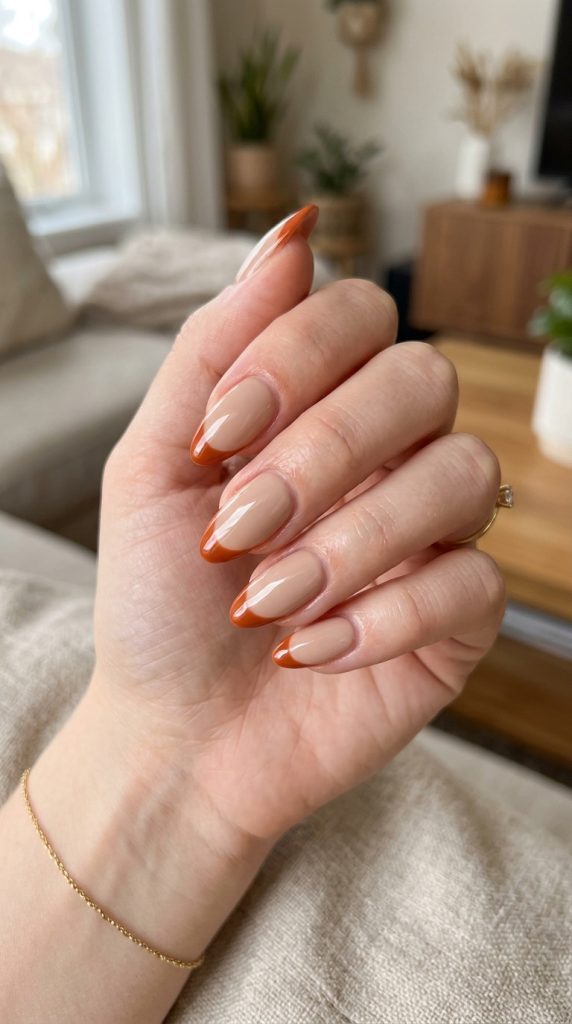 Nude manicure with burnt orange accent nail design
