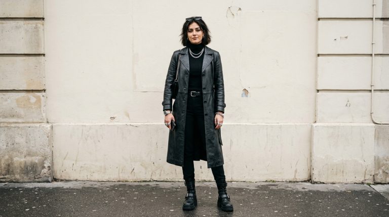 Woman in a black leather trench coat and all-black edgy outfit