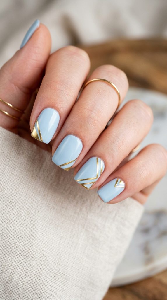 Nude manicure with geometric gold corner detail design